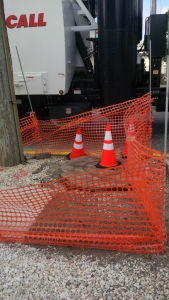 Caisson set on Ocean Drive for new pole. The old wooden pole is on the left side of the picture. The circle where the traffic cone is placed represents the diameter and location of the new pole.